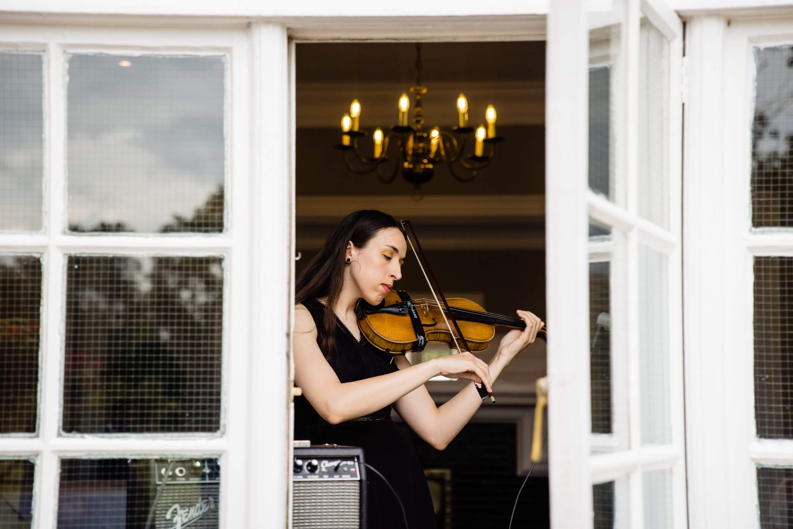 Violinist playing through an open window