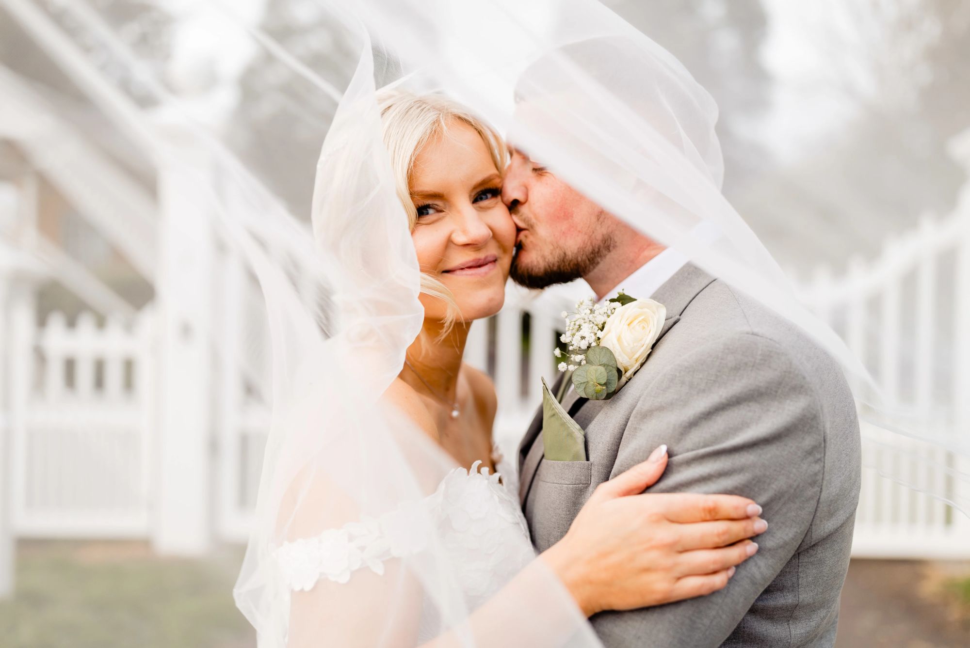 Romantic veil kiss portrait of bride and groom at their Hampshire wedding venue, Hampshire countryside wedding photography